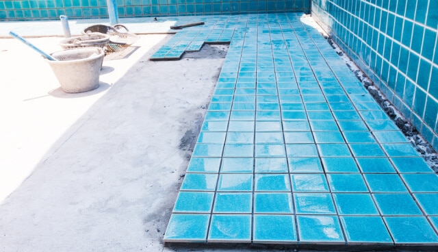 Pool floor tiles being placed