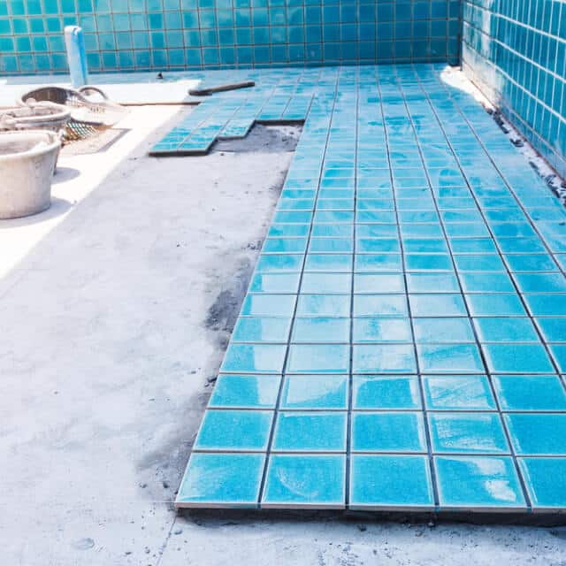 Pool floor tiles being placed